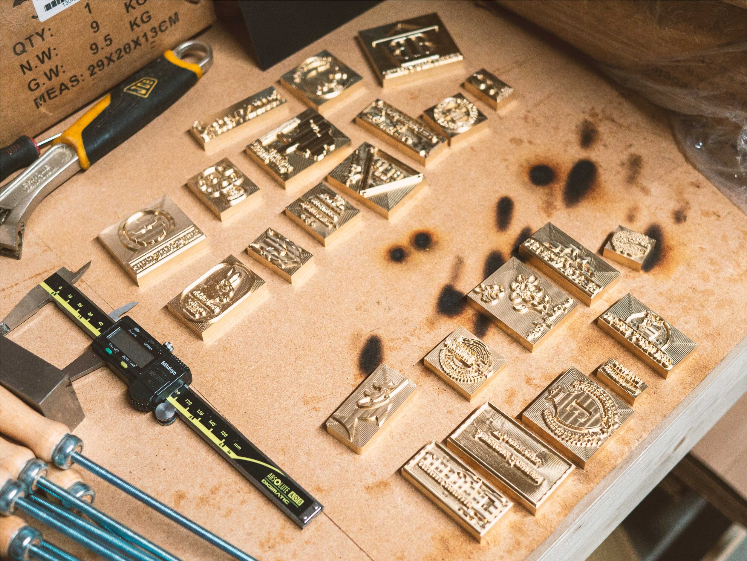 Branding Irons & Leather Embossing Stamps Laid Out on Table - Outpost Workshop